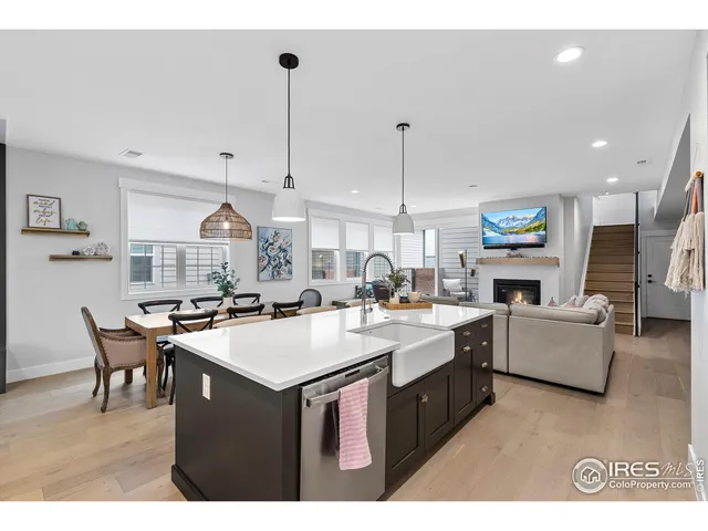 a open kitchen with a table chairs stove and wooden floor