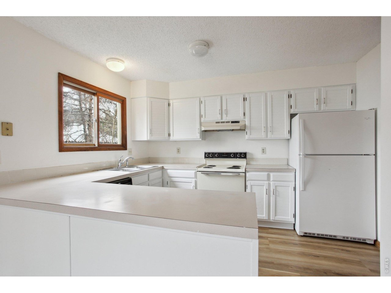 2651 9th Street Boulder, CO 80304 - Photo 5 of 25 a kitchen with stainless steel appliances granite countertop a refrigerator sink stove and white cabinets