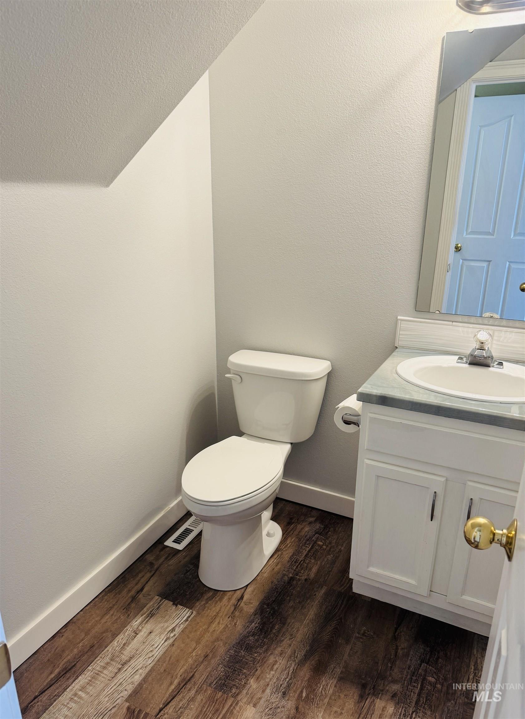 3203 South Capistrano Avenue Boise, ID 83705 - Photo 10 of 30 Half bathroom with vanity, dark wood finished floors, and a textured wall