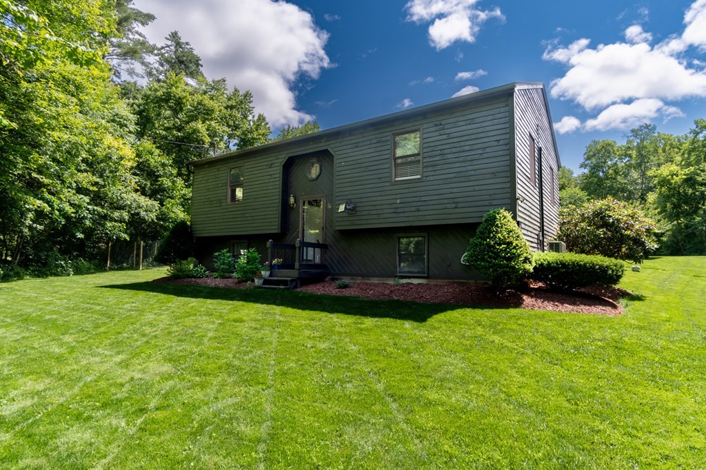 76 River Road Ware, MA 01082 - Photo 2 of 30 a front view of a house with a garden and plants