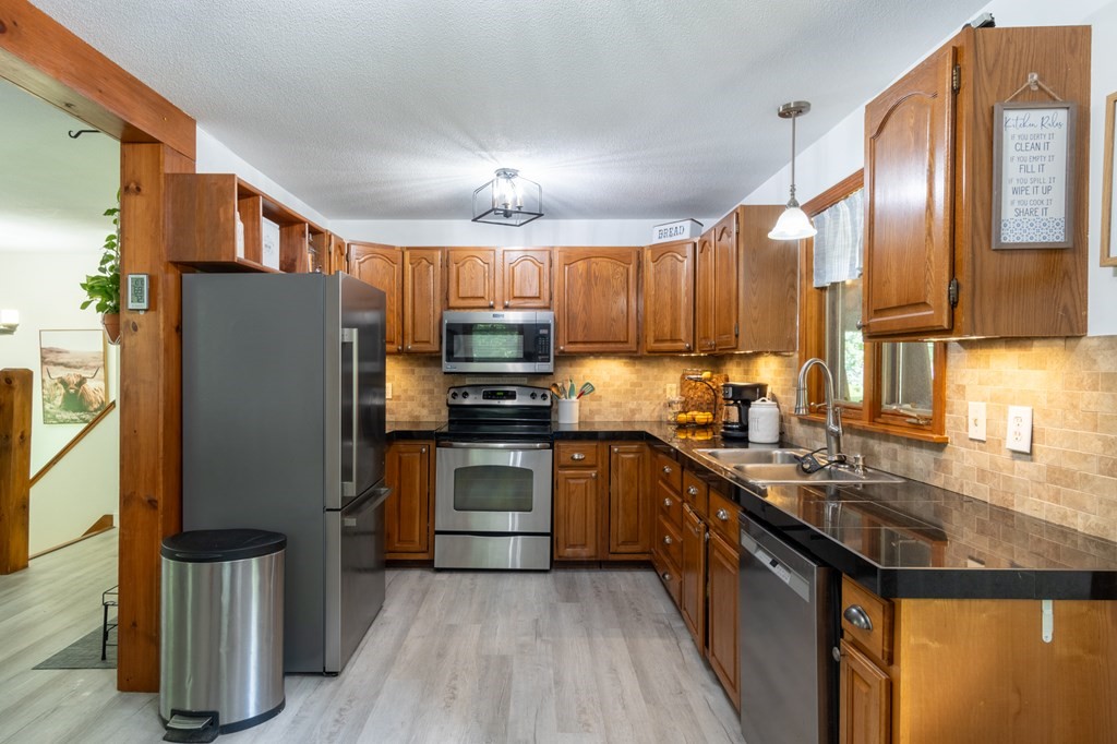 76 River Road Ware, MA 01082 - Photo 3 of 30 a kitchen with stainless steel appliances granite countertop a refrigerator a stove top oven a sink and dishwasher