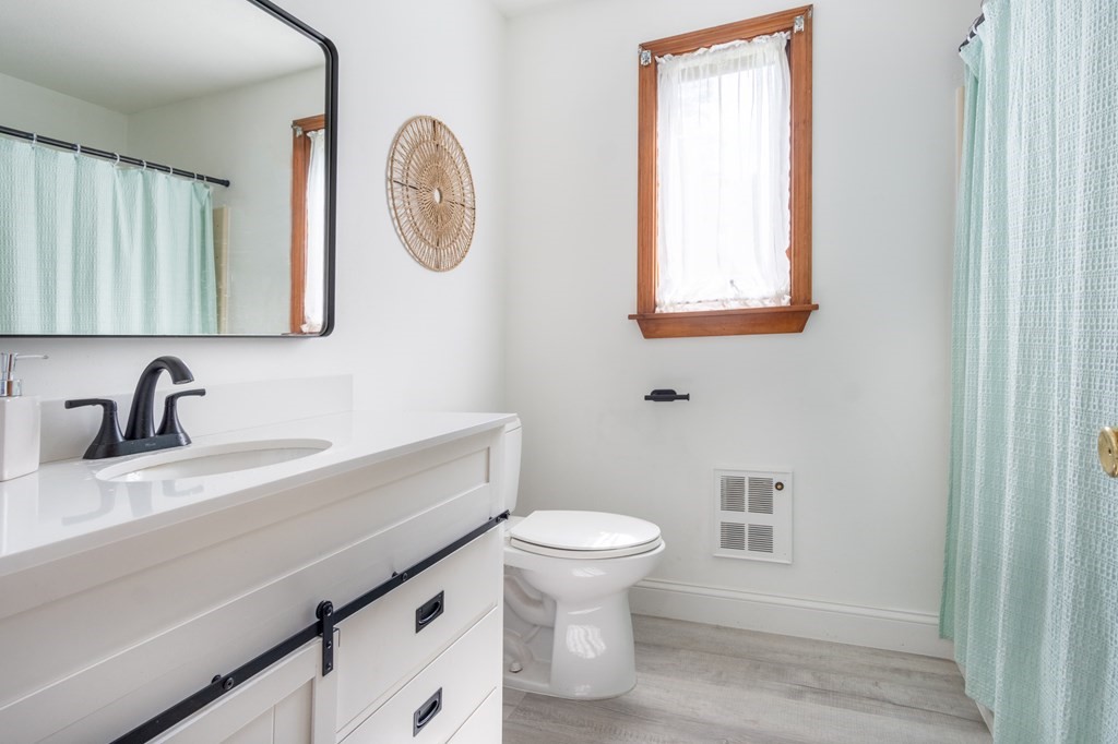 76 River Road Ware, MA 01082 - Photo 8 of 30 a bathroom with a toilet a sink a mirror and a window