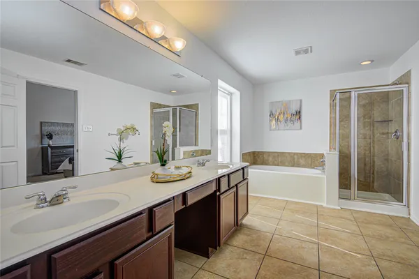 a spacious bathroom with a bathtub sink and mirror