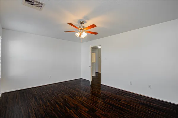 a view of an empty room with wooden floor