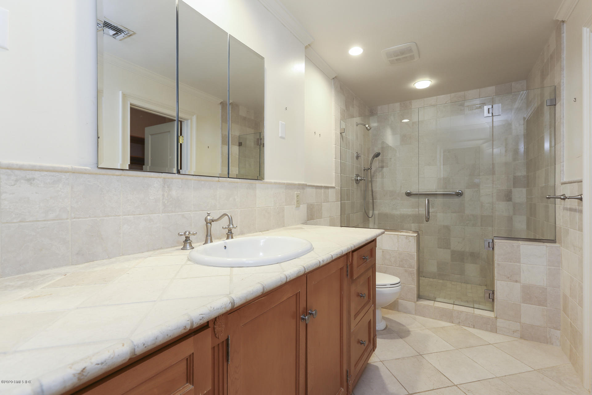 680 Steamboat Road, Unit 6 Greenwich, CT 06830 - Photo 16 of 40 a bathroom with a granite countertop sink mirror and shower