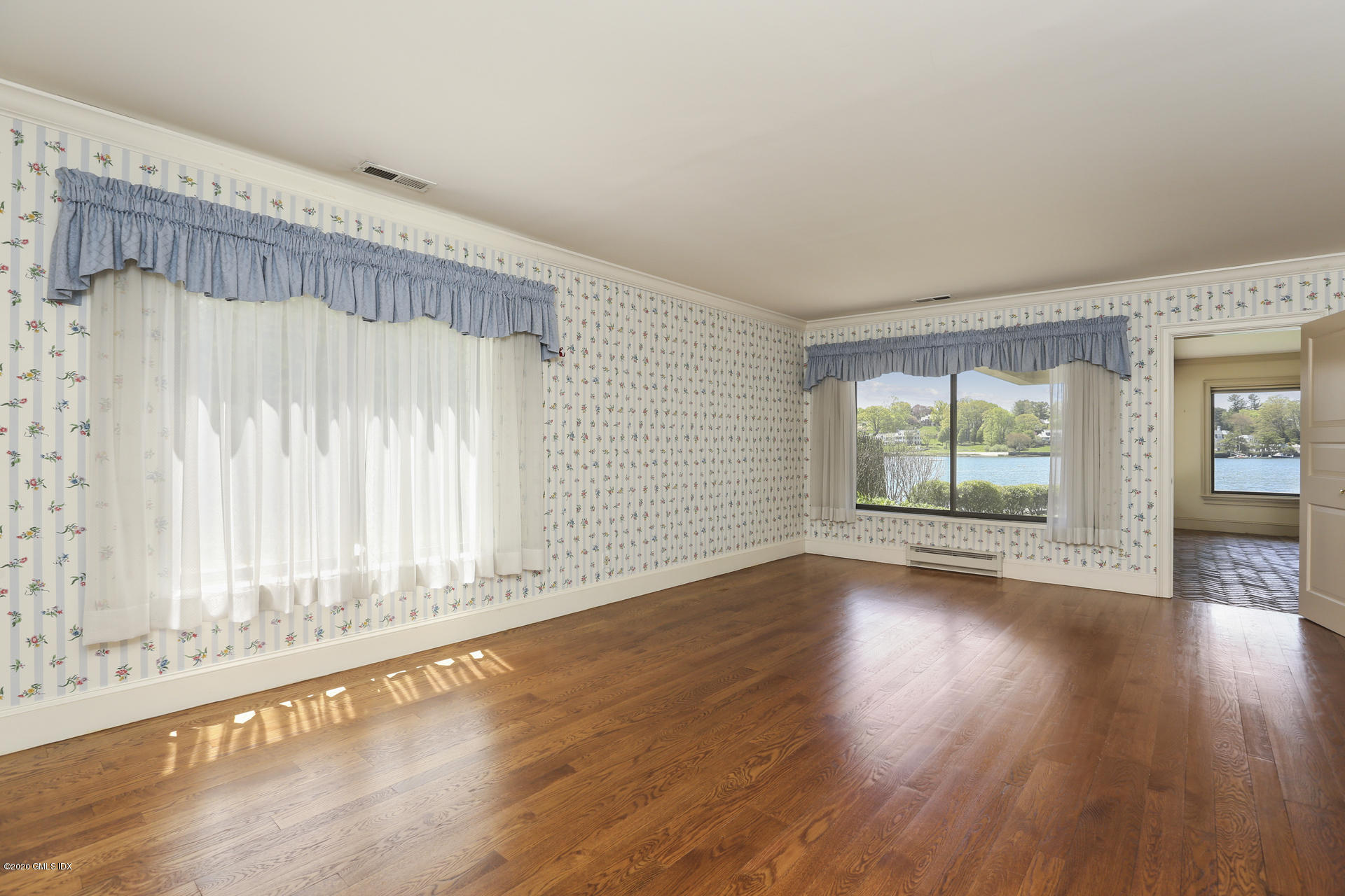 680 Steamboat Road, Unit 6 Greenwich, CT 06830 - Photo 27 of 40 an empty room with wooden floor and windows