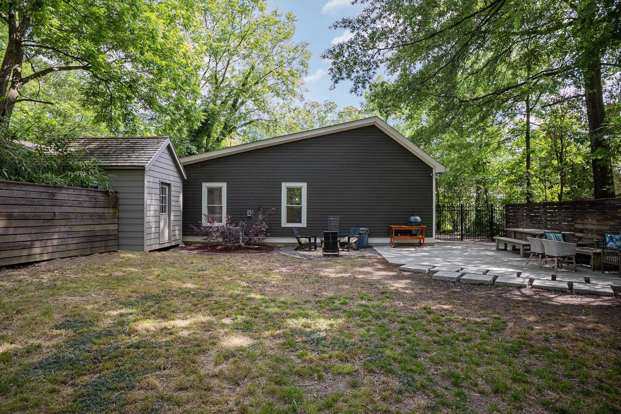908 Burch Avenue Durham, NC 27701 - Photo 21 of 27 a backyard of a house with table and chairs under an large tree