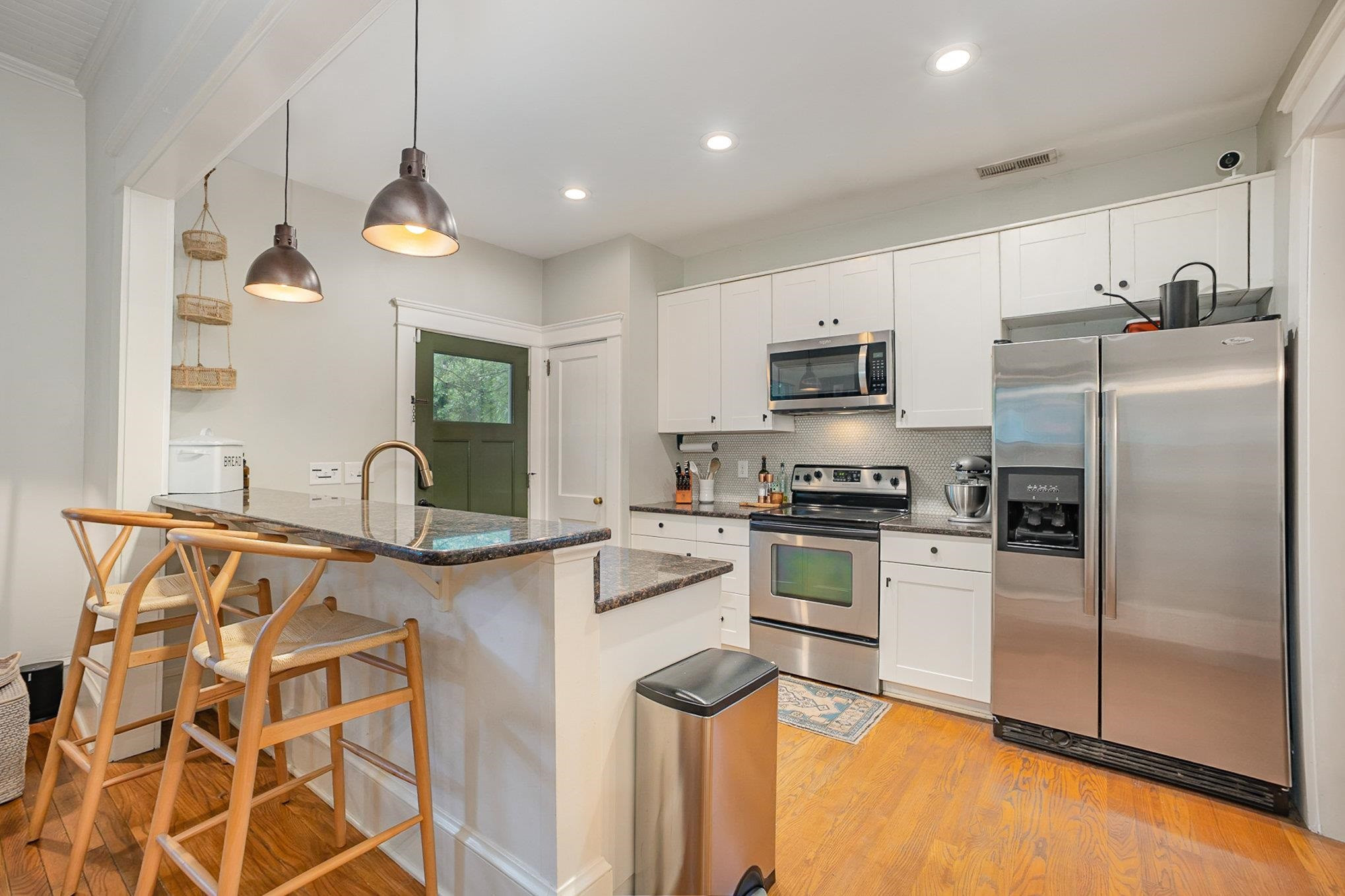 908 Burch Avenue Durham, NC 27701 - Photo 10 of 27 a kitchen with stainless steel appliances granite countertop a sink a stove a refrigerator a microwave oven with cabinets and wooden floor