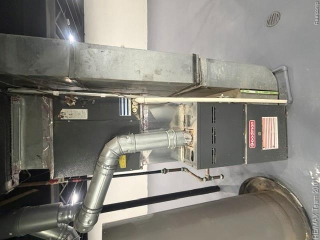 580 Palmerston Street River Rouge, MI 48218 - Photo 17 of 19 Goodman furnace unit with associated ductwork and piping, set on a gray finished floor with a floor drain