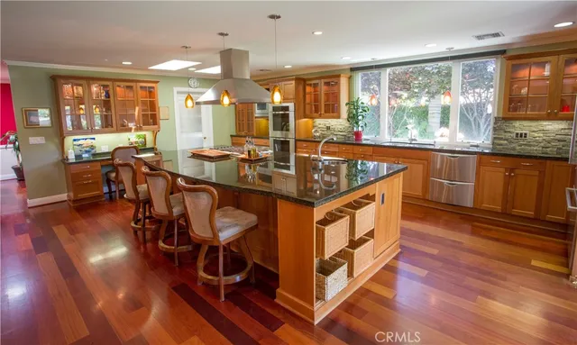 a kitchen with stainless steel appliances granite countertop a stove and a wooden floors