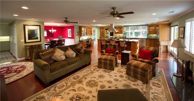 a living room with furniture kitchen view and a flat screen tv