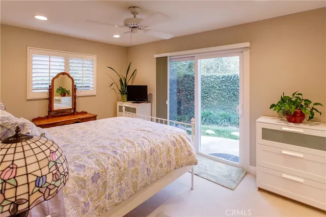 a bedroom with a bed and large windows