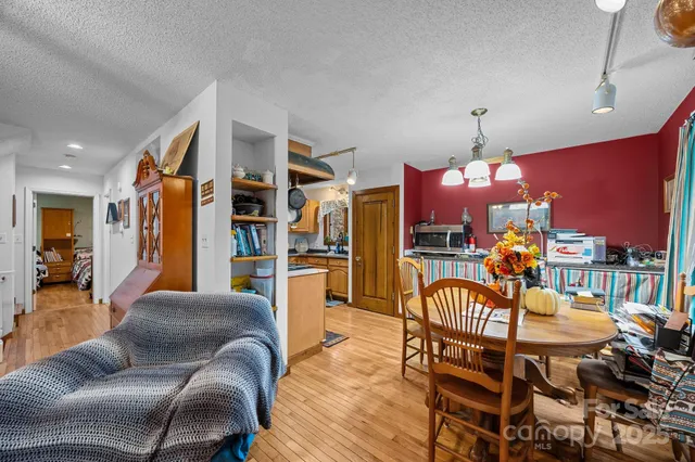 a living room with furniture kitchen view and a chandelier