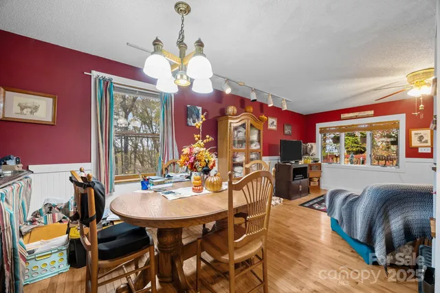 a view of a dining room with furniture a chandelier and wooden floor