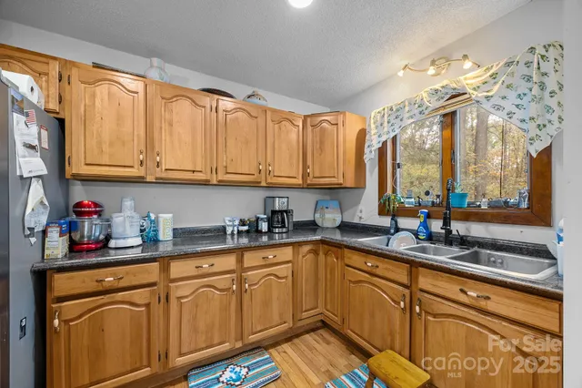 a kitchen with stainless steel appliances granite countertop a sink a stove and cabinets