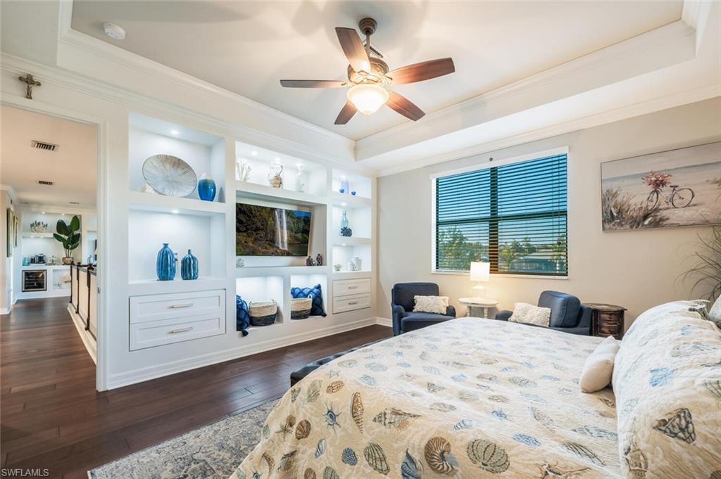 2115 Antigua Lane Naples, FL 34120 - Photo 22 of 41 Bedroom with crown molding, dark wood-type flooring, a tray ceiling, and a ceiling fan