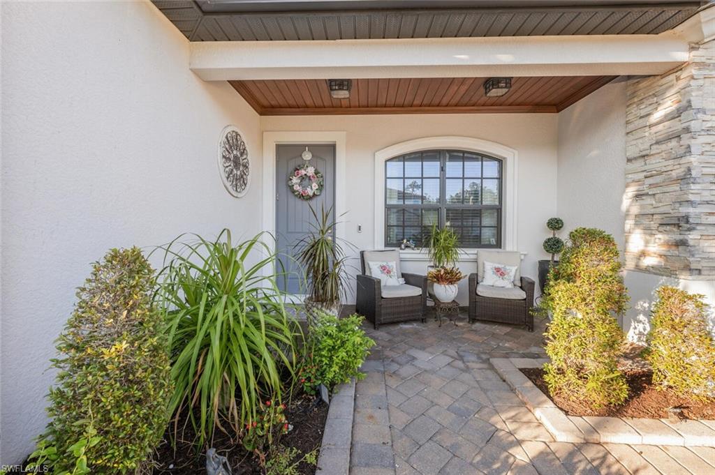 2115 Antigua Lane Naples, FL 34120 - Photo 6 of 41 View of exterior entry with stucco siding and a porch