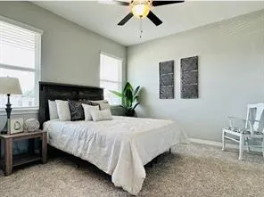 a bedroom with a bed a chandelier and a chair