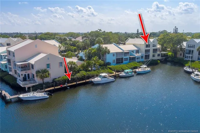 a view of white house with a yard and potted plants