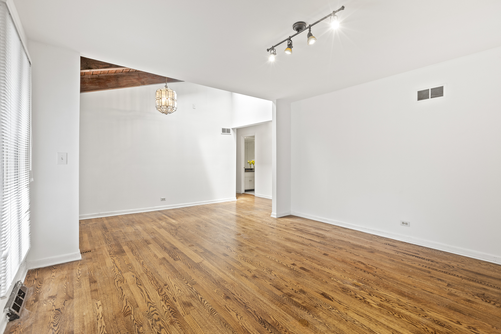 1046 Illinois Road Wilmette, IL 60091 - Photo 11 of 24 a view of an empty room with wooden floor and a ceiling fan
