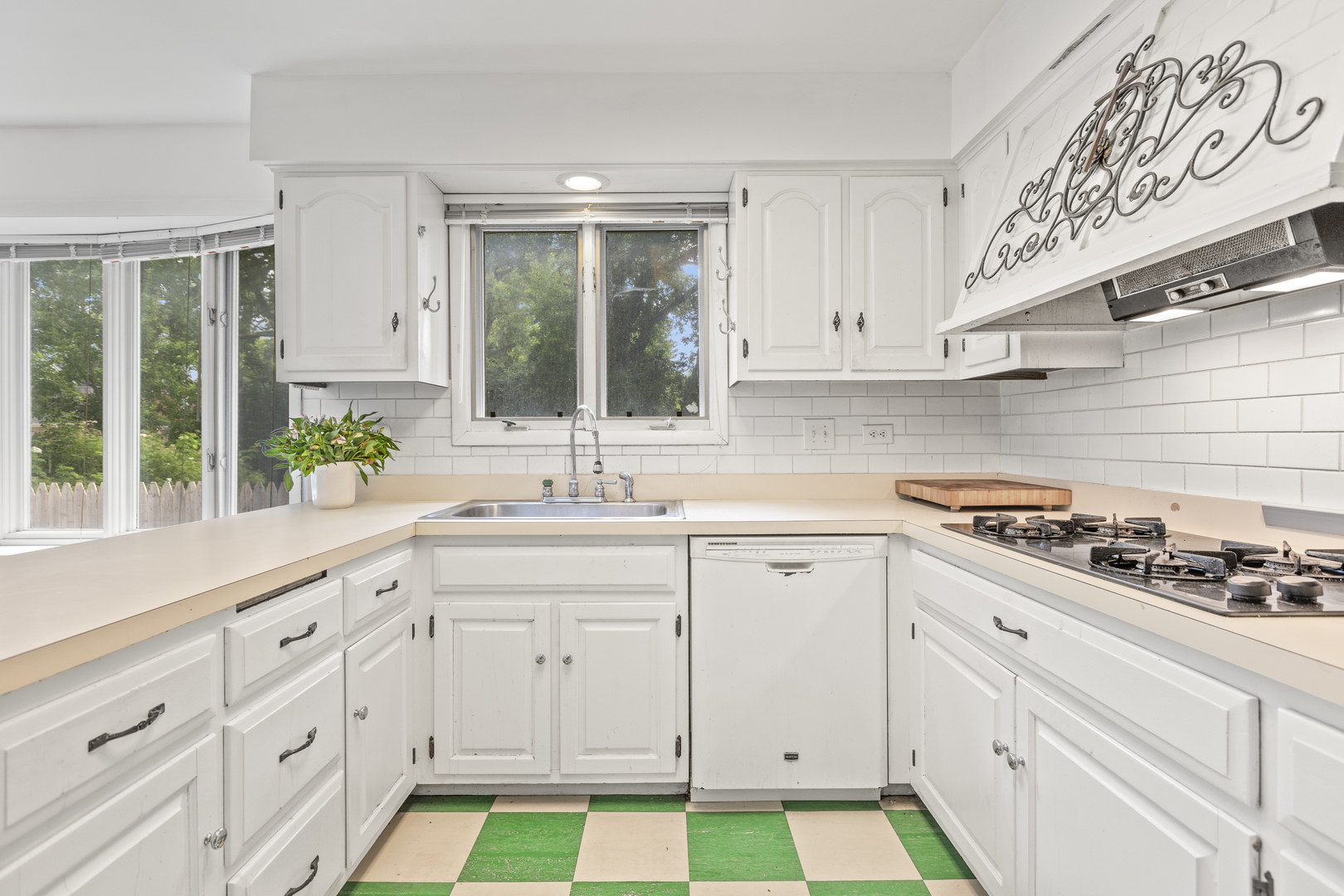 1046 Illinois Road Wilmette, IL 60091 - Photo 5 of 24 a kitchen with white cabinets a sink a stove and wooden floors