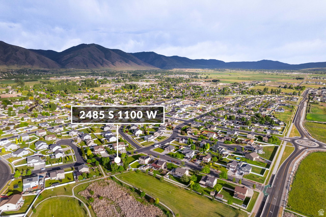 2485 South 1100th Street West Logan, UT 84321 - Photo 50 of 53 Aerial perspective showcasing a residential neighborhood with surrounding green spaces and distant mountains