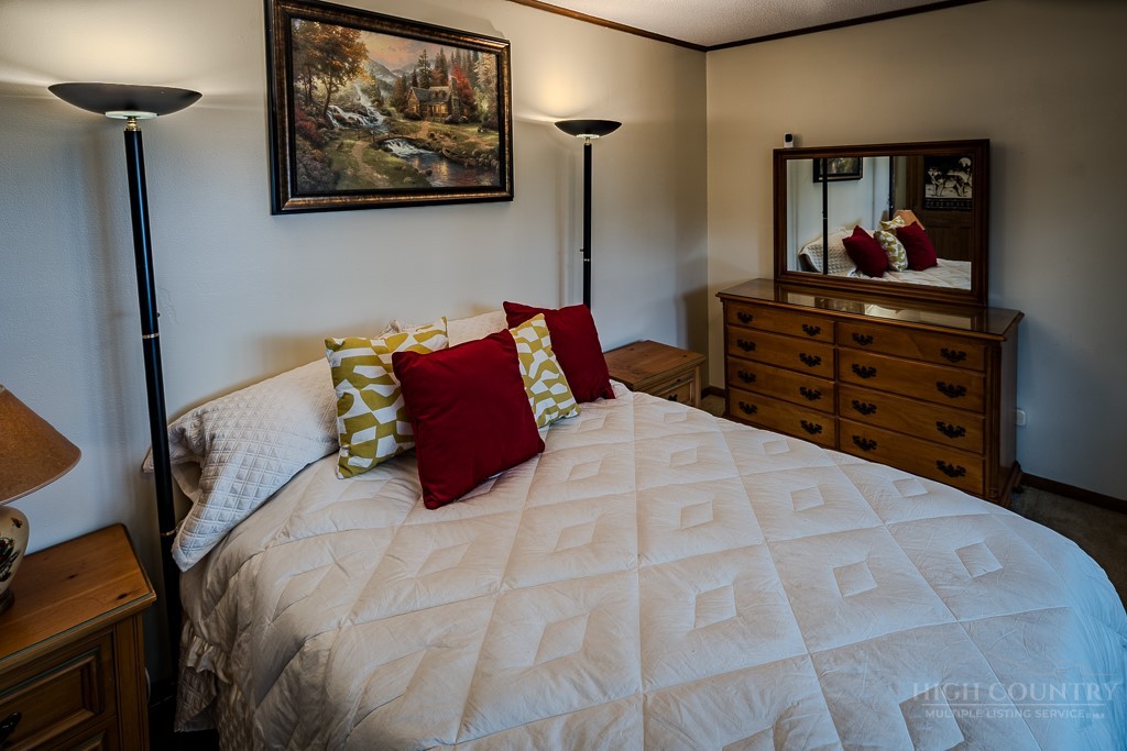 103-105 Upper Grouse Ridge Road Beech Mountain, NC 28604 - Photo 25 of 48 a bedroom with a bed and a painting on the wall