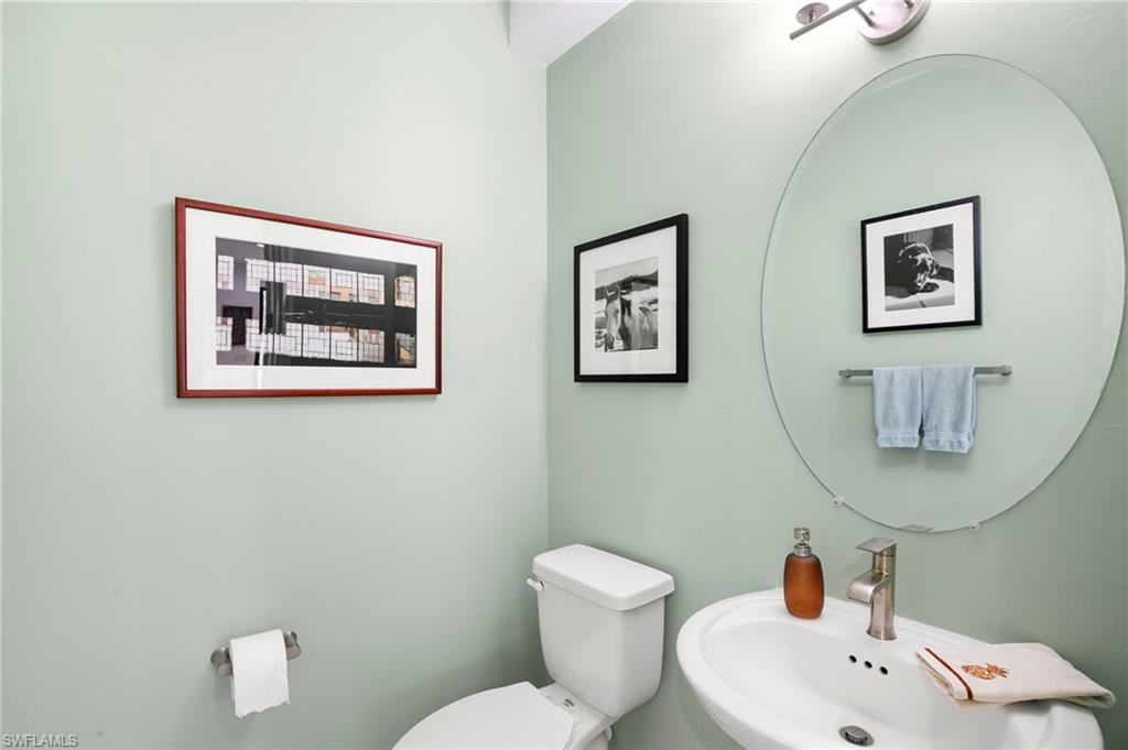 7515 Morgan Way Naples, FL 34119 - Photo 11 of 34 a bathroom with a toilet sink and mirror