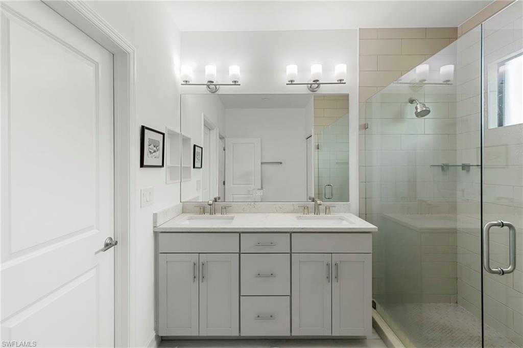 7515 Morgan Way Naples, FL 34119 - Photo 14 of 34 a bathroom with a double vanity sink mirror and shower