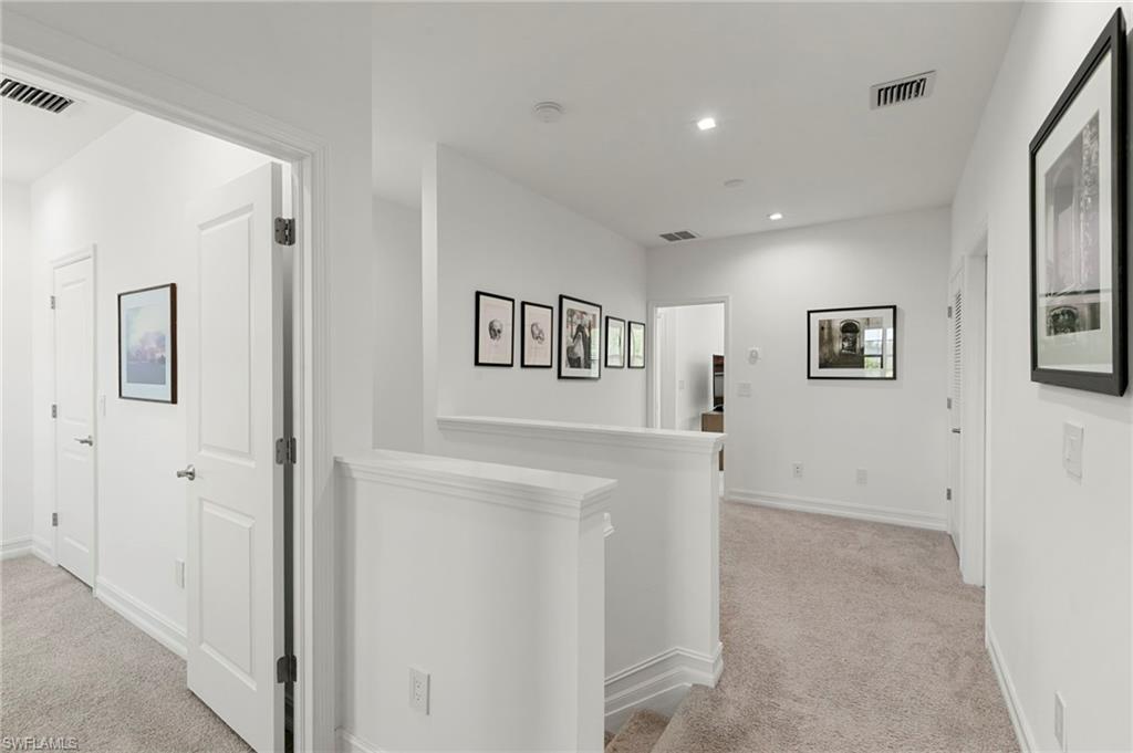 7515 Morgan Way Naples, FL 34119 - Photo 19 of 34 a view of a hallway with wooden floor and cabinet