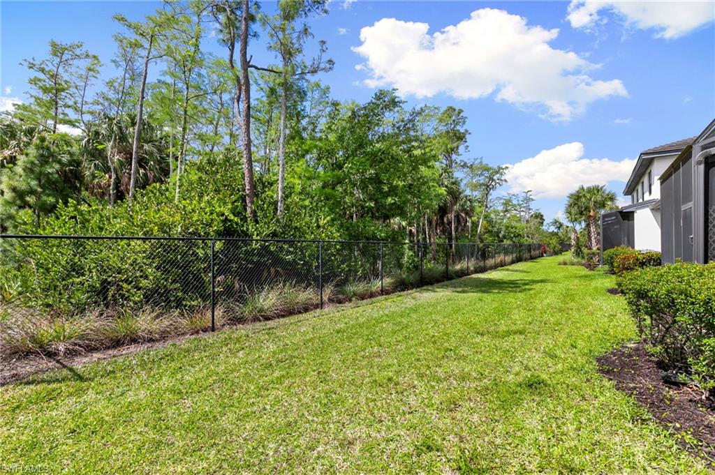 7515 Morgan Way Naples, FL 34119 - Photo 23 of 34 a view of a yard with plants and a bench