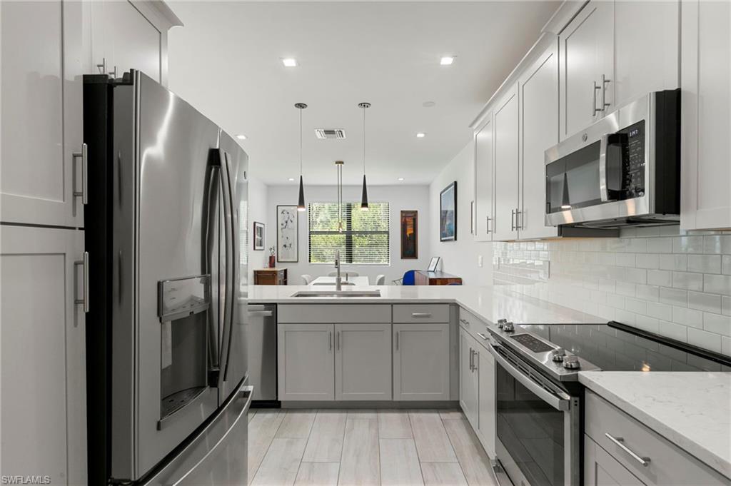 7515 Morgan Way Naples, FL 34119 - Photo 10 of 34 a kitchen with stainless steel appliances a refrigerator stove and sink