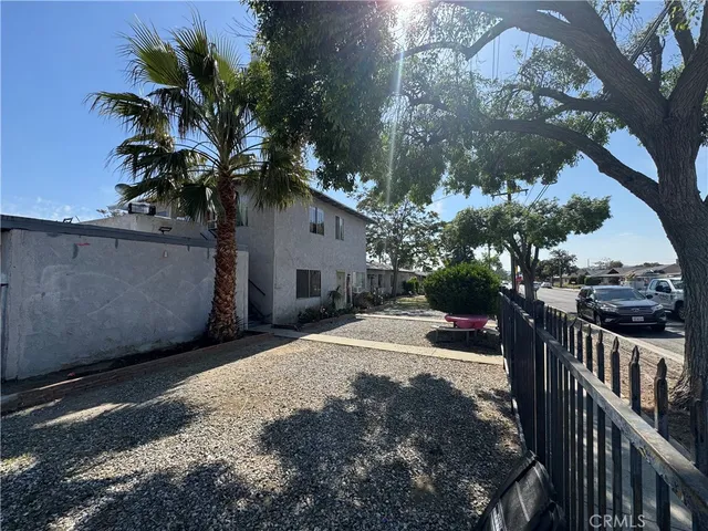 a view of a house with wooden fence next to a road