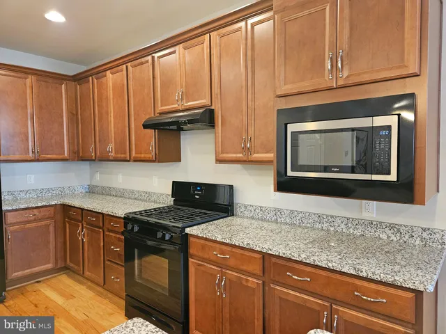 a kitchen with stainless steel appliances granite countertop a sink stove and cabinets