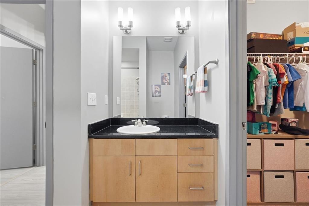 5300 Peachtree Road, Unit 2604 Atlanta, GA 30341 - Photo 23 of 39 a bathroom with a granite countertop sink a mirror and shower