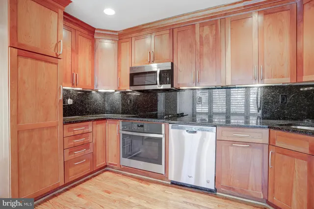 a kitchen with stainless steel appliances granite countertop a refrigerator a stove a sink and dishwasher