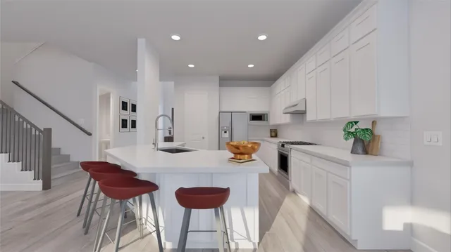 a kitchen with stainless steel appliances kitchen island granite countertop a dining table chairs and a refrigerator