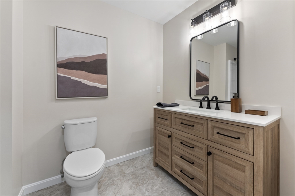 282 Loudville Road, Unit 1 Easthampton, MA 01027 - Photo 17 of 40 a bathroom with a toilet a sink and mirror