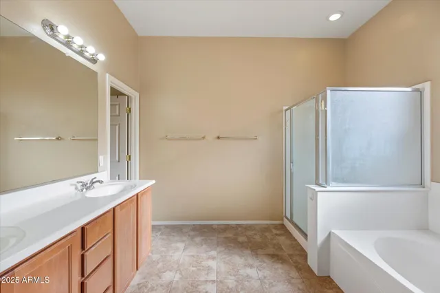 a bathroom with a double vanity sink a mirror and a bathtub