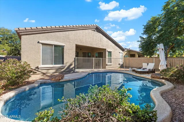 a view of a house with pool and chairs