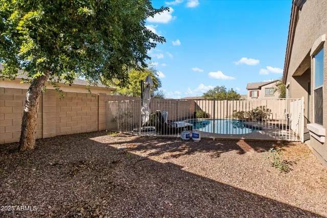 a backyard of a house with barbeque oven table and chairs