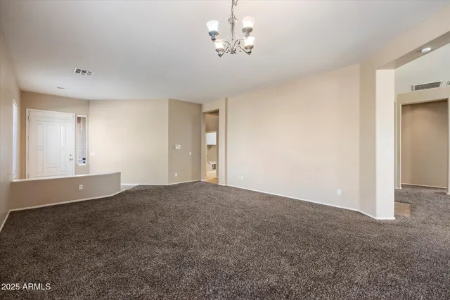 a view of empty room with chandelier fan