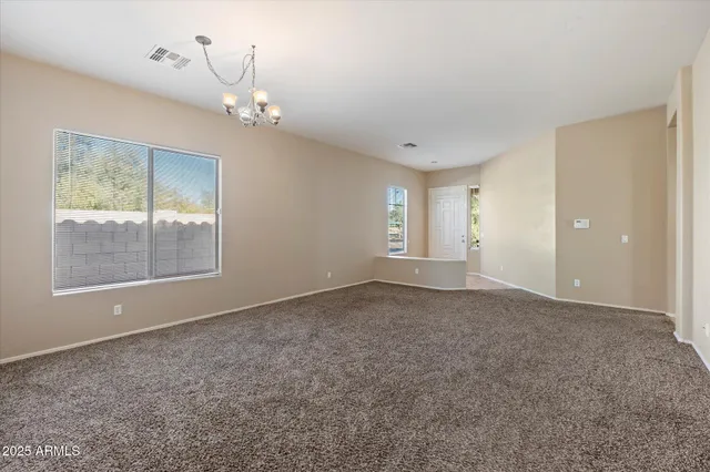 an empty room with windows and chandelier