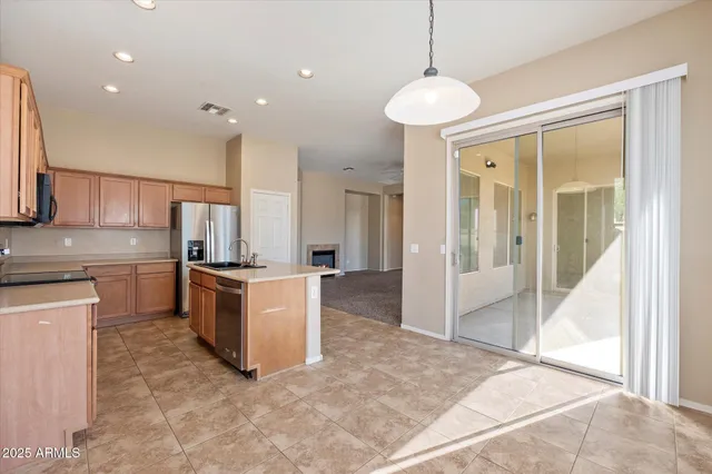 a large kitchen with a large counter top and stainless steel appliances