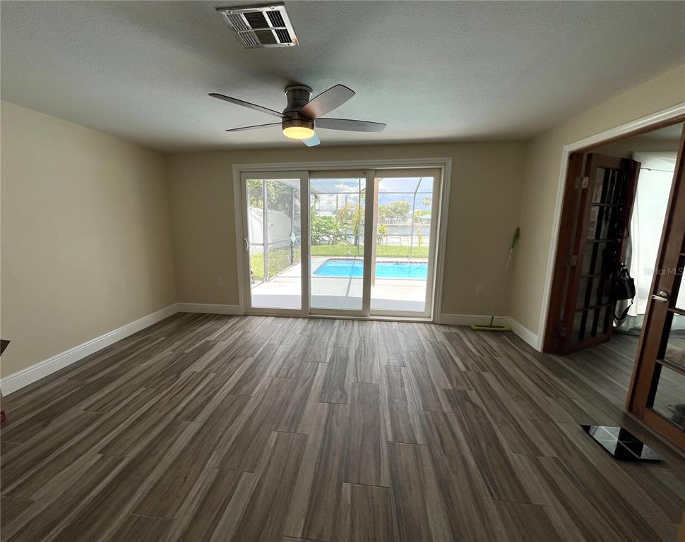 13630 Lagoon Drive Hudson, FL 34667 - Photo 8 of 26 an empty room with wooden floor and windows