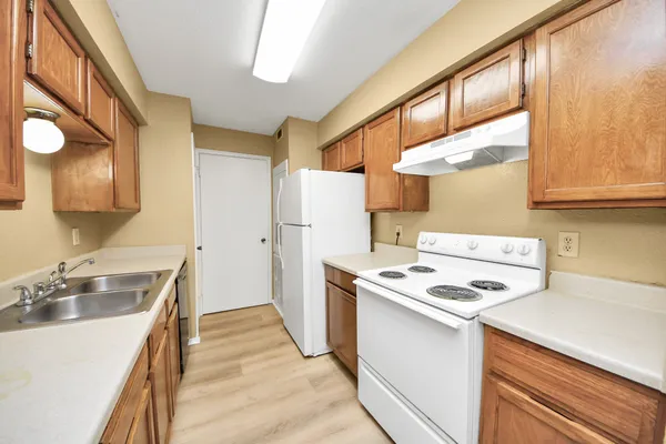 a kitchen that has a sink a stove and a refrigerator