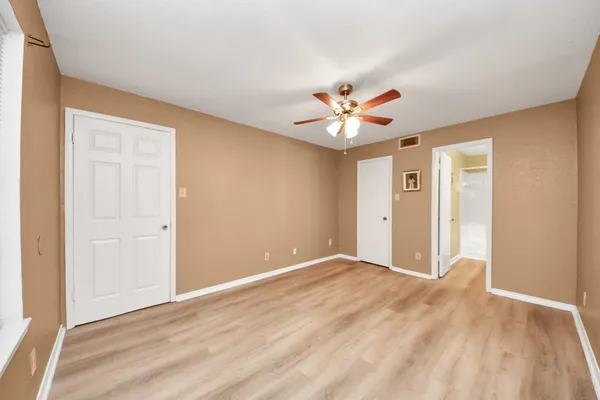 a view of a big room with closet and a chandelier fan