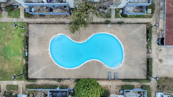 an aerial view of a house with outdoor space and swimming pool