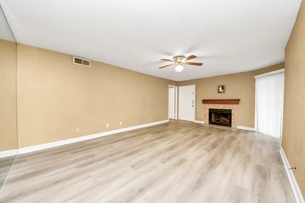 a view of empty room with fireplace and fan