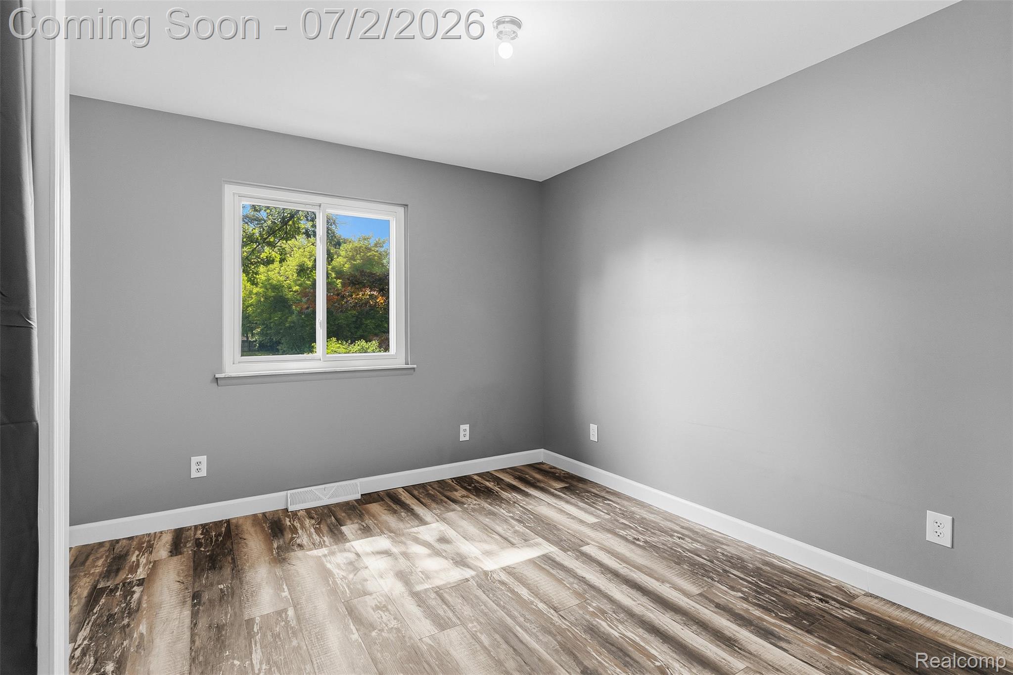 305 East Road Holly, MI 48442 - Photo 15 of 41 Interior room featuring wood-finish flooring, light gray walls, and white baseboards